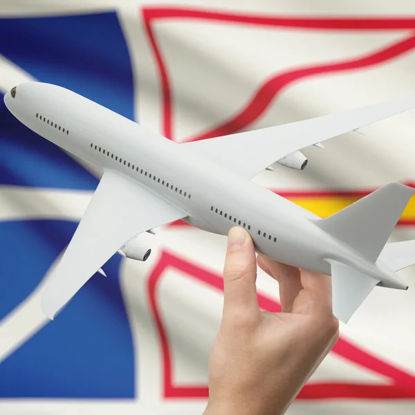 Airplane in hand with Canadian province flag on background series - Newfoundland and Labrador — Stock Photo, Image