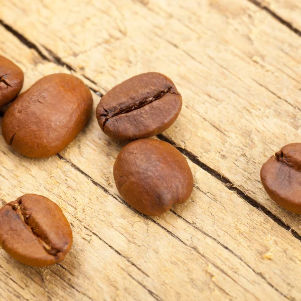 Well roasted coffee beans on old wooden table - studio shot — Stock Photo, Image