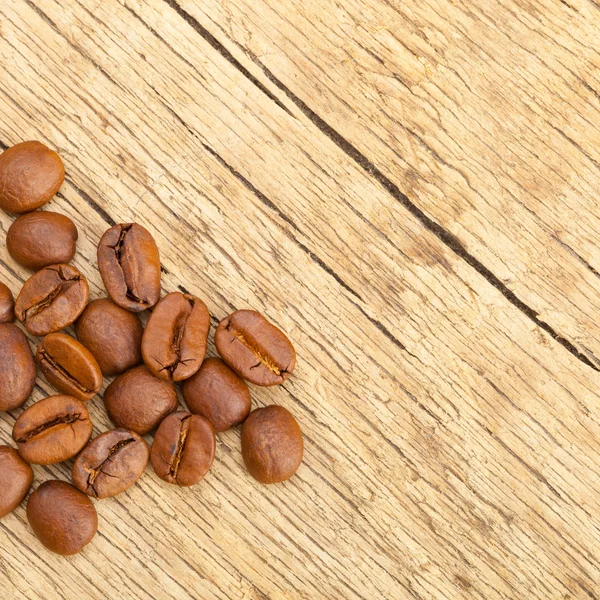 Well roasted coffee beans on old rustic wooden table - studio shot — Stock Photo, Image