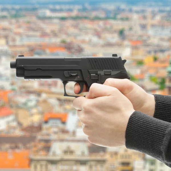 Close-up de fotos de homem com uma arma pronta para atirar - concentre-se na arma e turva — Fotografia de Stock