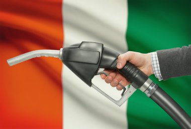 Yakıt pompa meme el ile ulusal bayrağını arka plan - Fildişi Sahili