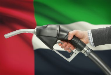 Yakıt pompa meme el ile ulusal bayrağını arka plan - Birleşik Arap Emirlikleri
