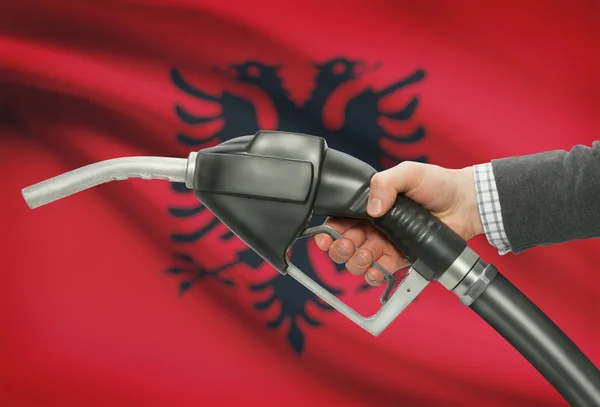 Gicleur de pompe de carburant dans la main avec un drapeau national sur fond - Albanie — Photo