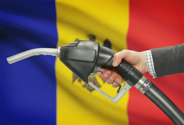 Bocal da bomba de combustível na mão com a bandeira nacional no plano de fundo - Moldávia — Fotografia de Stock