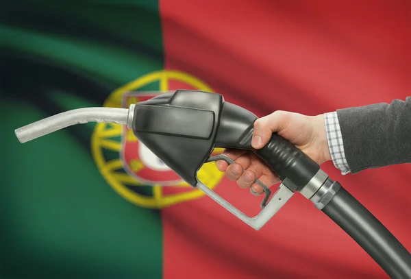 Bocal da bomba de combustível na mão com a bandeira nacional no plano de fundo - Portugal — Fotografia de Stock