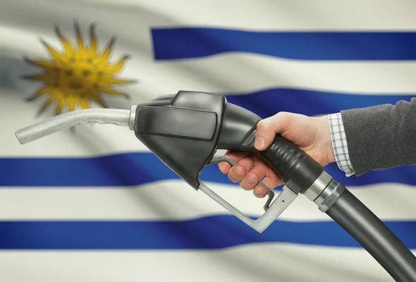 Inyector de la bomba de combustible de la mano con la bandera nacional de fondo - Uruguay — Foto de Stock