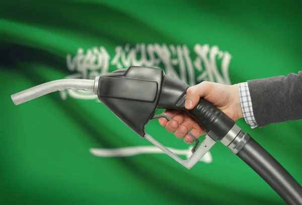 Gicleur de pompe de carburant dans la main avec un drapeau national sur fond - Arabie saoudite — Photo