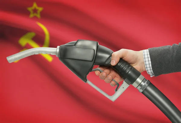 Gicleur de pompe de carburant dans la main avec un drapeau national sur fond - URSS - URSS — Photo