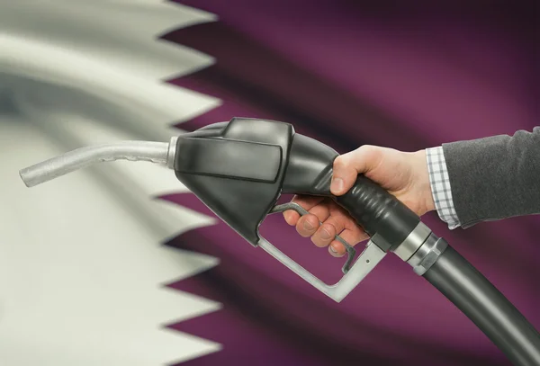 Brandstof pomp mondstuk in de hand met nationale vlag op achtergrond - Qatar — Stockfoto