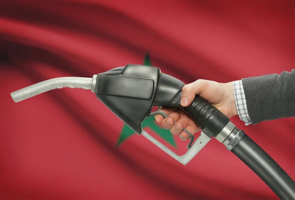 Ugello della pompa di carburante in mano con la bandiera nazionale su priorità bassa - Marocco — Foto Stock