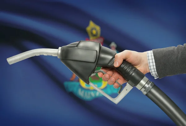 Buse de la pompe à carburant dans la main avec Usa Etats drapeaux sur fond - Maine — Photo
