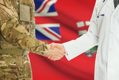 Military man in uniform and doctor shaking hands with Canadian provincies and territories flags on background - Manitoba