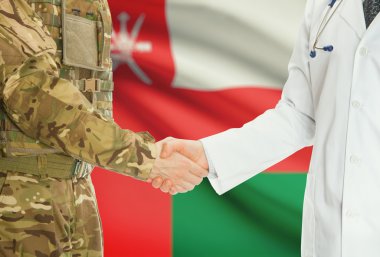 Military man in uniform and doctor shaking hands with national flag on background - Oman