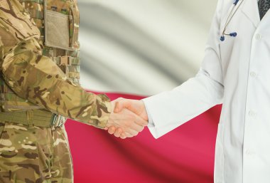 Military man in uniform and doctor shaking hands with national flag on background - Poland