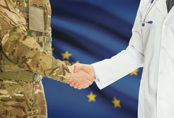 Military man in uniform and doctor shaking hands with US states flags on background - Alaska — Foto Stock
