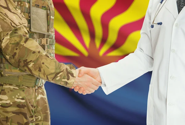 Military man in uniform and doctor shaking hands with US states flags on background - Arkansas — Foto de Stock