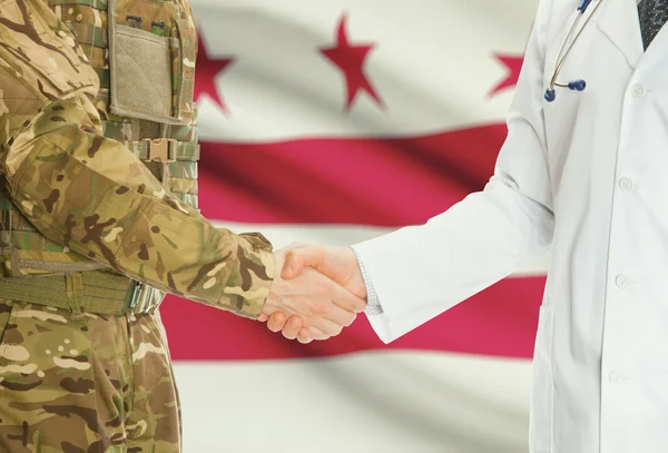 Homme militaire en uniforme et le médecin se serrant la main avec nous drapeaux d'états sur fond - District of Columbia — Photo