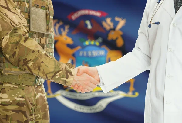 Military man in uniform and doctor shaking hands with US states flags on background - Michigan — Stok fotoğraf