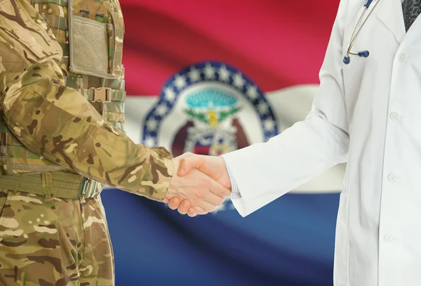 Military man in uniform and doctor shaking hands with US states flags on background - Missouri - Stock-foto