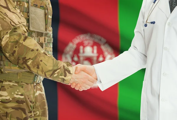 Homme militaire en uniforme et le médecin se serrant la main avec le drapeau national sur le fond - Afghanistan — Photo
