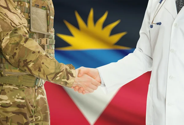 Военный человек в военной форме и доктор рукопожатием с национальным флагом на фоне - Антигуа и Барбуда — стоковое фото