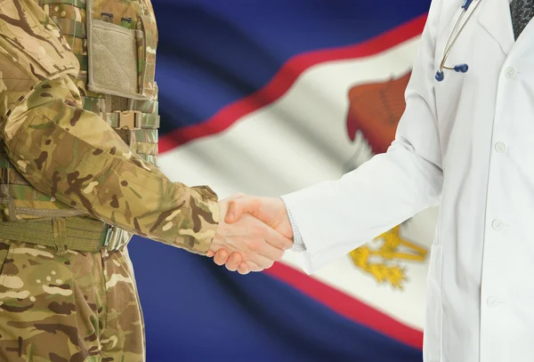 Military man in uniform and doctor shaking hands with national flag on background - American Samoa — 图库照片