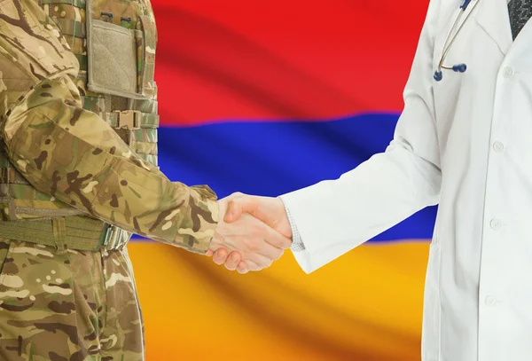 Homme militaire en uniforme et le médecin se serrant la main avec le drapeau national sur le fond - Arménie — Photo