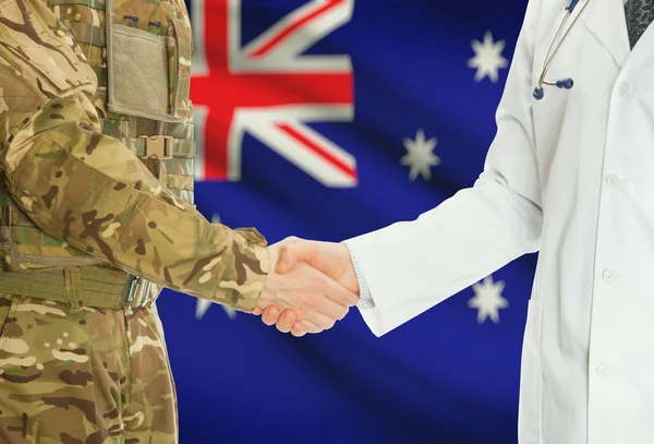 Military man in uniform and doctor shaking hands with national flag on background - Australia — Zdjęcie stockowe