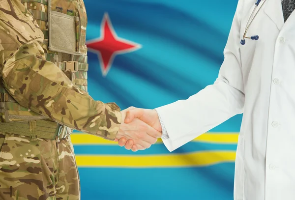 Military man in uniform and doctor shaking hands with national flag on background - Aruba