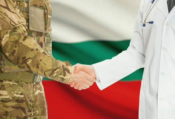 Military man in uniform and doctor shaking hands with national flag on background - Bulgaria