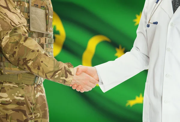 Homme militaire en uniforme et le médecin se serrant la main avec le drapeau national sur le fond - Cocos (Keeling) — Photo