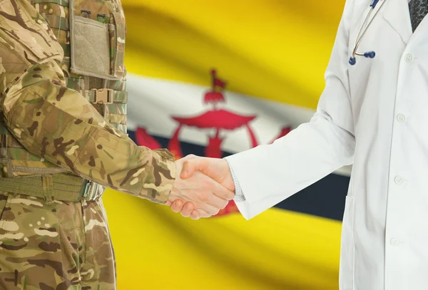 Military man in uniform and doctor shaking hands with national flag on background - Brunei — Stok fotoğraf