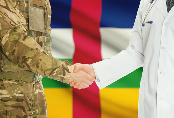 Military man in uniform and doctor shaking hands with national flag on background - Central African Republic — Stok fotoğraf