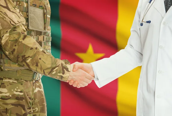Military man in uniform and doctor shaking hands with national flag on background - Cameroon — Zdjęcie stockowe