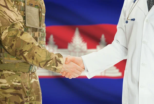 Military man in uniform and doctor shaking hands with national flag on background - Cambodia — Stok fotoğraf