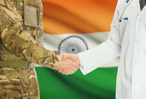 Military man in uniform and doctor shaking hands with national flag on background - India — 스톡 사진