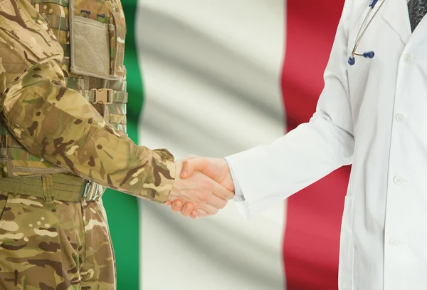 Homme militaire en uniforme et le médecin se serrant la main avec le drapeau national sur le fond - Italie — Photo