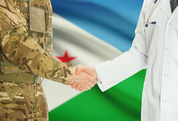 Homme militaire en uniforme et le médecin se serrant la main avec le drapeau national sur le fond - Djibouti — Photo
