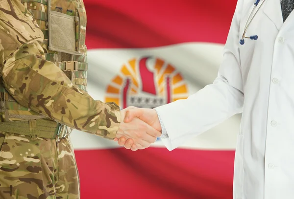 Homme militaire en uniforme et le médecin se serrant la main avec le drapeau national sur le fond - Polynésie française — Photo