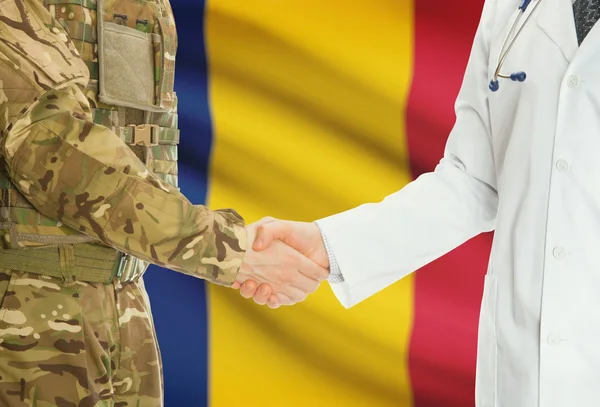 Military man in uniform and doctor shaking hands with national flag on background - Romania — Stok fotoğraf