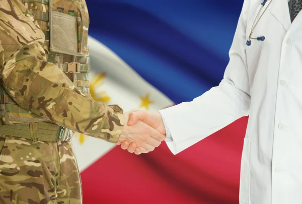 Homme militaire en uniforme et le médecin se serrant la main avec le drapeau national sur le fond - Philippines — Photo