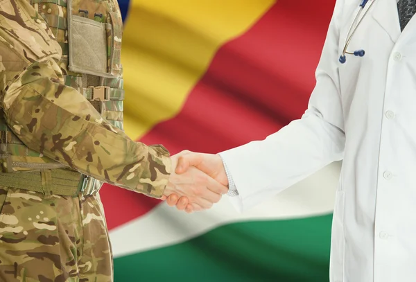 Military man in uniform and doctor shaking hands with national flag on background - Seychelles — Stock Photo, Image