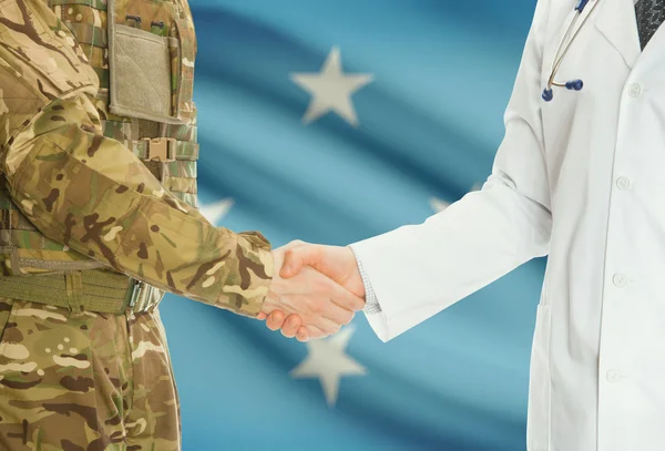 Homme militaire en uniforme et le médecin se serrant la main avec le drapeau national sur le fond - Micronésie — Photo