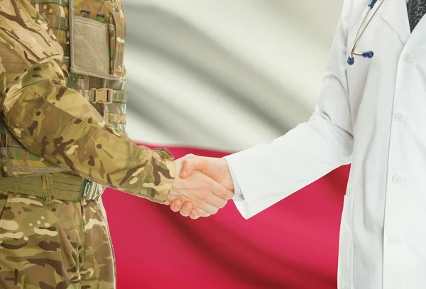 Military man in uniform and doctor shaking hands with national flag on background - Poland — Stock Photo, Image