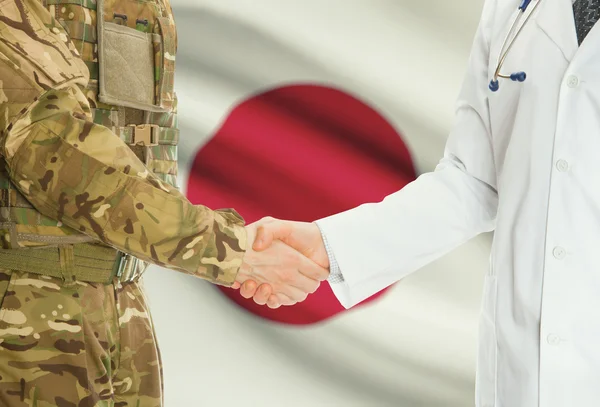 Military man in uniform and doctor shaking hands with national flag on background - Japan — стокове фото