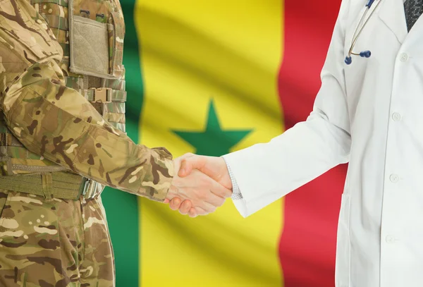 Military man in uniform and doctor shaking hands with national flag on background - Senegal — Zdjęcie stockowe