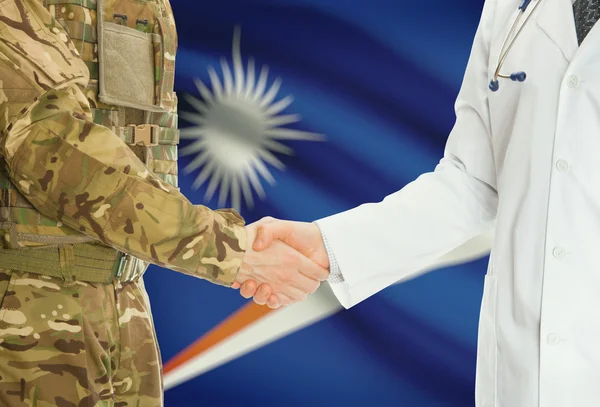 Military man in uniform and doctor shaking hands with national flag on background - Marshall Islands