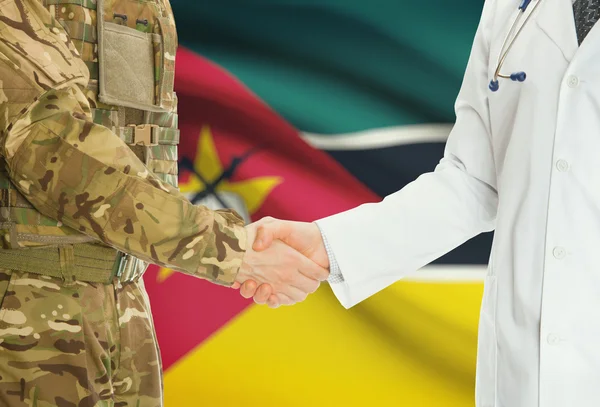 Military man in uniform and doctor shaking hands with national flag on background - Mozambique — Stok fotoğraf