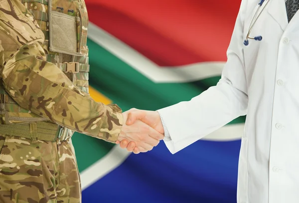 Military man in uniform and doctor shaking hands with national flag on background - South Africa — Stock Photo, Image