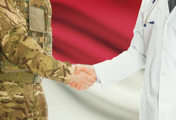 Military man in uniform and doctor shaking hands with national flag on background - Monaco — Stock Photo, Image